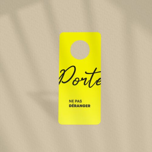 Une étiquette jaune de porte avec un message en français : "Ne pas déranger".