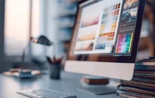 Bureau de graphiste avec écran affichant une interface de design et une palette de couleurs